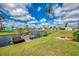 Waterfront backyard featuring a wooden dock, fire pit, and lush landscaping, perfect for outdoor living at 6627 Marius Rd, North Port, FL 34287