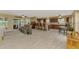 Open floor plan with kitchen bar, tile floors, ceiling fan, and sliders to the outdoor area at 6627 Marius Rd, North Port, FL 34287