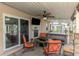 Outdoor covered patio featuring comfortable seating, a TV, and access to the screened pool area at 6627 Marius Rd, North Port, FL 34287