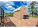 Outdoor shed adjacent to a brick patio and a grill, perfect for storage and outdoor cooking at 6627 Marius Rd, North Port, FL 34287
