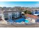Aerial shot of a three-story condo with a pool, a lounge, a restroom building, and parking spots at 110 Vista Hermosa Cir # 102B, Sarasota, FL 34242