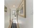 Hallway featuring a neutral tile floor, artwork, and a view of the front door at 110 Vista Hermosa Cir # 102B, Sarasota, FL 34242