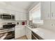 Updated kitchen with stainless steel appliances, light cabinets, and granite countertops at 110 Vista Hermosa Cir # 102B, Sarasota, FL 34242