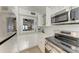 White kitchen featuring modern appliances, tile backsplash, and a breakfast bar pass-through at 110 Vista Hermosa Cir # 102B, Sarasota, FL 34242