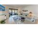 Inviting living room with tile floors, beachy decor, and sliding glass doors to a patio at 110 Vista Hermosa Cir # 102B, Sarasota, FL 34242
