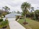 Aerial view of house with two-car garage, driveway, and palm trees at 1422 Evangelina Ln, North Port, FL 34286