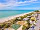 Scenic aerial of a beach community with a sandy beach, turquoise water, a basketball court, and convenient parking under a blue sky at 14724 Ponce De Leon Trl, Port Charlotte, FL 33981
