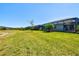 A large backyard is a great area for to play and includes a view of neighboring homes and the community lake at 14724 Ponce De Leon Trl, Port Charlotte, FL 33981
