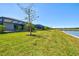 Lush backyard features a screen enclosed lanai with a view of the lake at 14724 Ponce De Leon Trl, Port Charlotte, FL 33981