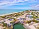 Aerial perspective of a beach town offering beach access and inviting waterfront dining at a Tiki Bar under a sunny blue sky at 14724 Ponce De Leon Trl, Port Charlotte, FL 33981