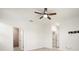 Neutral bedroom with ceiling fan, open doors to the bathroom and closet at 14724 Ponce De Leon Trl, Port Charlotte, FL 33981