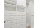 Spacious walk-in closet with custom shelving and drawer units for organized storage at 14724 Ponce De Leon Trl, Port Charlotte, FL 33981