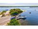 Aerial view showcasing a private dock, boats, and waterfront access to the tranquil waters of the bay in a serene tropical setting at 14724 Ponce De Leon Trl, Port Charlotte, FL 33981