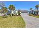 Welcoming home featuring gray shutter details, a lush green lawn and palm trees at 14724 Ponce De Leon Trl, Port Charlotte, FL 33981