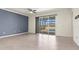 Empty living room with lots of natural light and a view of the pool area through a sliding glass door at 14724 Ponce De Leon Trl, Port Charlotte, FL 33981