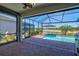 Inviting outdoor space showcasing a screened-in lanai with a swimming pool and picturesque lake view at 14724 Ponce De Leon Trl, Port Charlotte, FL 33981