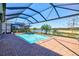 Sparkling pool area with screened enclosure overlooking a serene lake view at 14724 Ponce De Leon Trl, Port Charlotte, FL 33981