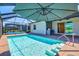 Sparkling swimming pool within a screened-in patio area, offering a private and refreshing retreat at 14724 Ponce De Leon Trl, Port Charlotte, FL 33981