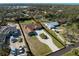 Aerial view of the property showcasing lush surroundings, screened-in pool, and large driveway at 1611 Thomas St, Englewood, FL 34223