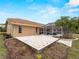 View of backyard with stone paver patio, and view of screened-in pool and covered patio at 1611 Thomas St, Englewood, FL 34223