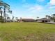 Large green backyard showing the exterior, with a view of multiple houses in the distance at 1611 Thomas St, Englewood, FL 34223