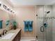 Bathroom featuring granite countertop, framed mirror, modern vanity lighting, and glass enclosed tiled shower at 1611 Thomas St, Englewood, FL 34223