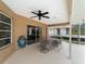 View of covered patio features outdoor dining set, ceiling fan, and sliding glass doors to interior at 1611 Thomas St, Englewood, FL 34223