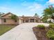 Attractive home with a spacious driveway, mature palm trees, and gorgeous landscaping at 1611 Thomas St, Englewood, FL 34223