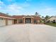 Exterior showcasing large paved driveway with immaculate shrubbery and palms, and a two car garage at 1611 Thomas St, Englewood, FL 34223