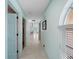 Long hallway with tile flooring, neutral paint and natural light through the arched windows at 1611 Thomas St, Englewood, FL 34223