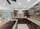 Kitchen with wood cabinets, granite countertops, tile backsplash, and stainless steel dishwasher at 1611 Thomas St, Englewood, FL 34223