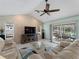 Living room boasts vaulted ceilings, brick accent wall, ceiling fan and sliding door access to the pool at 1611 Thomas St, Englewood, FL 34223