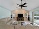 Living room boasts vaulted ceilings, brick accent wall, ceiling fan and sliding door access to the patio at 1611 Thomas St, Englewood, FL 34223