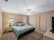 Spacious bedroom featuring neutral walls, carpet, and a large bed with decorative pillows and access to closets at 1611 Thomas St, Englewood, FL 34223