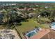 Aerial view of a screened-in pool and sprawling green yard surrounded by mature trees at 1611 Thomas St, Englewood, FL 34223