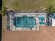 Aerial view of screened-in pool with clear water, patio furniture, well-maintained grass and palm trees at 1611 Thomas St, Englewood, FL 34223