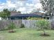 View of fenced backyard with mature landscaping, including a screen enclosed lanai at 4091 Pomeroy St, North Port, FL 34291