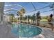 Sparkling swimming pool with a screened enclosure and lush tropical landscaping at 522 Fallbrook Dr, Venice, FL 34292