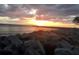 Beautiful sunset over the ocean with a rocky shoreline in the foreground at 523 Park Estates Sq, Venice, FL 34293