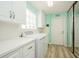 Bright laundry room featuring white cabinets, a modern washer/dryer, and sleek mirrored closet doors at 5755 Ivrea Dr, Sarasota, FL 34238