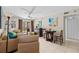 Cozy living room featuring neutral tones, ceiling fan, and sliding doors to the lanai at 104 Capri Isles Blvd # 107, Venice, FL 34292