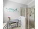 Bright bathroom featuring a glass-enclosed shower, vanity, and a fun, decorative mermaid at 10466 Medjool Dr, Venice, FL 34293
