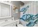 Bright bathroom featuring a white vanity, sea turtle wall decor, and a shower with turtle curtain at 10466 Medjool Dr, Venice, FL 34293