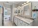 Bathroom featuring a dual sink vanity with stone counters, and access to the main bedroom at 10466 Medjool Dr, Venice, FL 34293