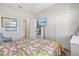 Bright bedroom with a view, features a patterned bedspread, closet, and wood-look flooring at 10466 Medjool Dr, Venice, FL 34293