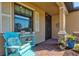 Inviting front porch with a blue chair, brick flooring, and decorative plants creating a warm welcome at 10466 Medjool Dr, Venice, FL 34293