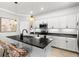 Modern kitchen featuring white cabinetry, black countertops, and stylish pendant lighting at 10466 Medjool Dr, Venice, FL 34293