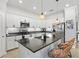 Modern kitchen with white cabinetry, black countertops, and stylish pendant lighting at 10466 Medjool Dr, Venice, FL 34293