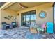 Relaxing outdoor patio featuring stylish furniture, coastal decor, and sliding glass doors to the interior at 10466 Medjool Dr, Venice, FL 34293
