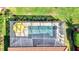 An aerial perspective shows a pool with a yellow umbrella surrounded by green landscaping and privacy screen at 10466 Medjool Dr, Venice, FL 34293